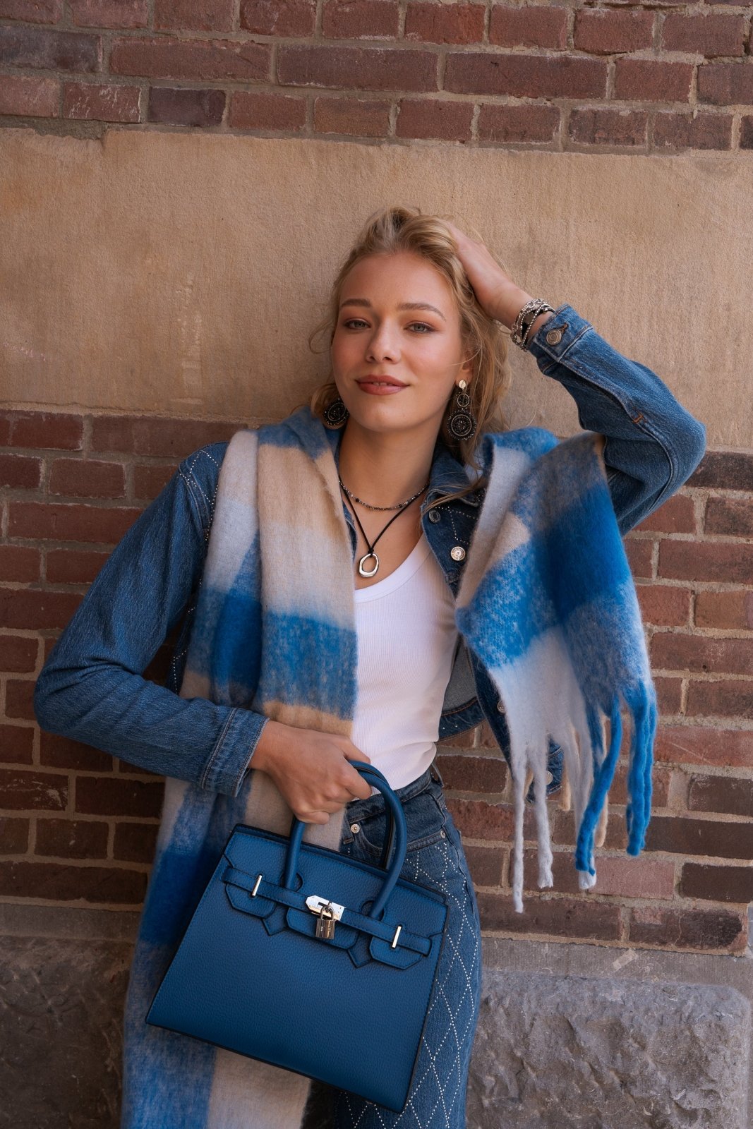 Blauwe handtas met zilverkleurige details en slotje